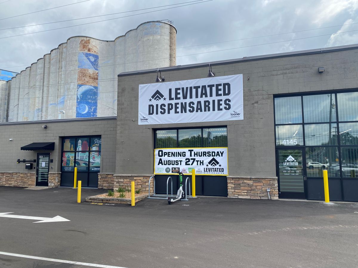 The Levitated Dispensaries storefront at 4145 Hiawatha Ave in Minneapolis, with the painted grain silos rising behind it